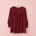 Blusa Julieta burdeos colgada en percha blanca sobre fondo rosa