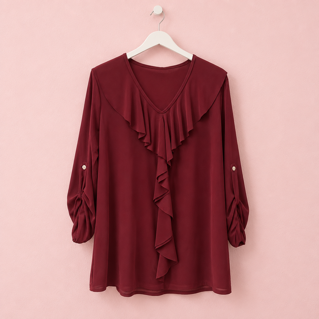 Blusa Julieta burdeos colgada en percha blanca sobre fondo rosa